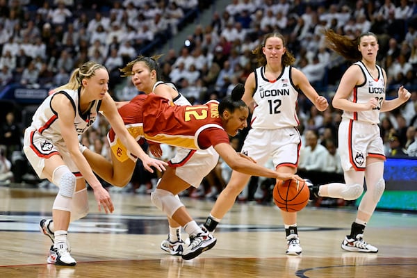 Southern California guard JuJu Watkins, second from front left, is fouled by UConn guard Kaitlyn Chen, second from back left, as UConn guards Paige Bueckers, left, and Ashlynn Shade, second from right, defend in the second half of an NCAA college basketball game, Saturday, Dec. 21, 2024, in Hartford, Conn. (AP Photo/Jessica Hill)