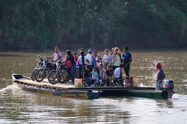 Residents cross the Tarra River to Venezuela from Colombia's Tibu, Tuesday, Jan. 21, 2025, following guerrilla attacks that killed dozens and forced thousands to flee their homes in the Catatumbo region. (AP Photo/Fernando Vergara)