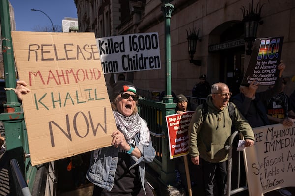 A protester raises signs during a demonstration in support of Palestinian activist Mahmoud Khalil outside Columbia University, Monday, March 10, 2025, in New York. (AP Photo/Yuki Iwamura)