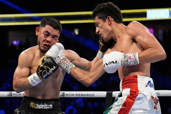 Rafael Espinoza hits Edward Vazquez in a featherweight title boxing match Sunday, May 4, 2025, in Las Vegas. (AP Photo/John Locher)