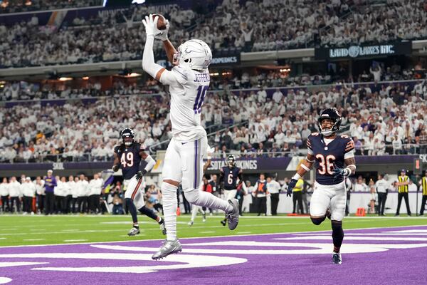 Minnesota Vikings wide receiver Justin Jefferson (18) catches a 7-yard touchdown pass in front of Chicago Bears safety Jonathan Owens (36) during the first half of an NFL football game, Monday, Dec. 16, 2024, in Minneapolis. (AP Photo/Abbie Parr)