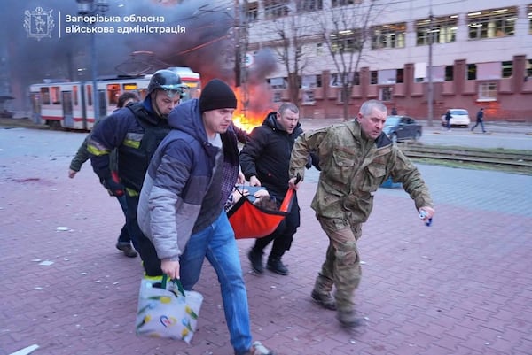 In this photo provided by the Zaporizhzhia regional military administration on Jan. 8, 2025, people carry an injured woman on a stretcher into an ambulance after a Russian air strike in Zaporizhzhia, Ukraine. (Zaporizhzhia regional military administration via AP)