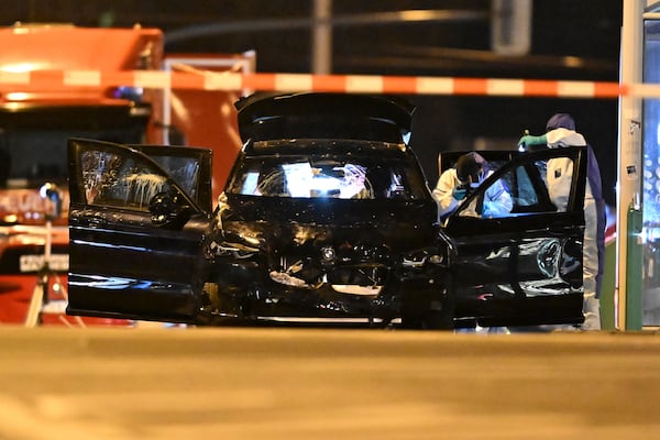 Forensics work on a damaged car sitting with its doors open after a driver plowed into a busy Christmas market in Magdeburg, Germany, early Saturday, Dec. 21, 2024. (Hendrik Schmidt/dpa via AP)