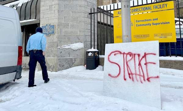 A corrections officer walks into Auburn Correctional Facility while several dozen coworkers strike across the street in Auburn, N.Y., Tuesday, Feb. 18, 2025 to protest unsafe working conditions. (Kevin Rivoli/The Citizen via AP)