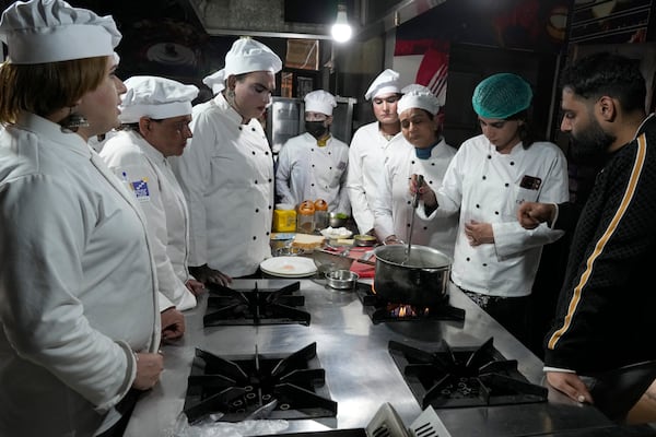 Chef Ali Haider, right, teaches transgender persons during their cooking class at the Culinary & Hotel Institute of Pakistan, in Lahore, Pakistan, Tuesday, Feb. 25, 2025. (AP Photo/K.M Chaudary)