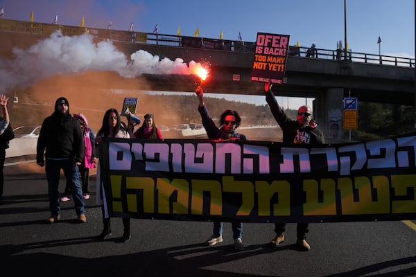 Relatives of hostages held by Hamas in the Gaza Strip block a highway between Jerusalem and Tel Aviv a day after the militant group announced it would delay a planned hostage release after accusing Israel of violating a fragile ceasefire. Tuesday, Feb. 11, 2025. (AP Photo/Ohad Zwigenberg)