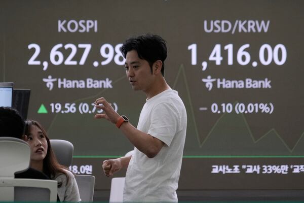Currency traders work near a screen showing the Korea Composite Stock Price Index (KOSPI), left, and the foreign exchange rate between U.S. dollar and South Korean won at the foreign exchange dealing room of the KEB Hana Bank headquarters in Seoul, South Korea, Wednesday, May 14, 2025. (AP Photo/Ahn Young-joon)