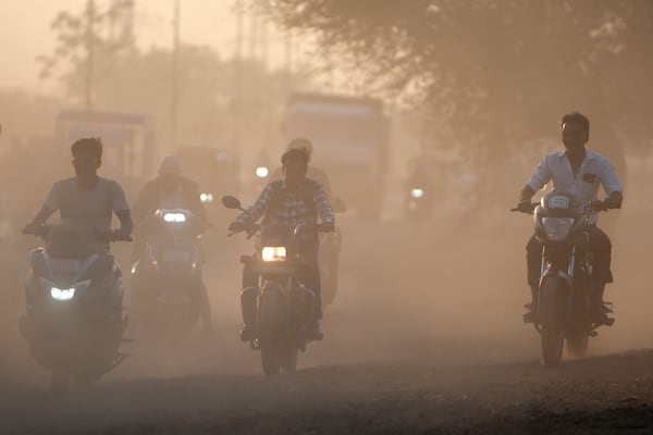 Dust rises as commuters drive past a road in Ahmedabad, India, on Feb. 5, 2025. (AP Photo/Ajit Solanki)