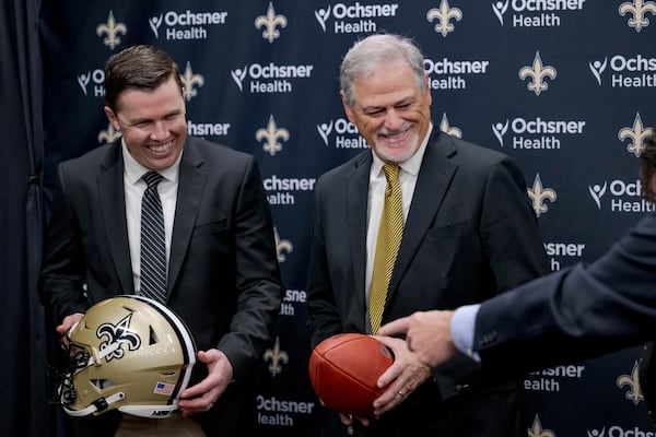 New Orlean Saints new coach Kellen Moore Kellen Moore, left, and Saints general manager Mickey Loomis, right, smile during an NFL football press conference in Metairie, La. Thursday, Feb. 13, 2025. (AP Photo/Matthew Hinton)