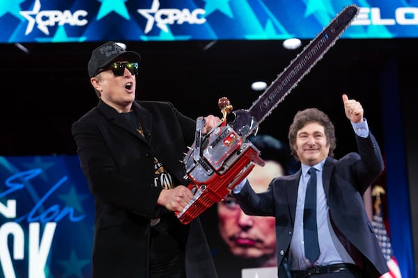 Elon Musk holds up a chainsaw he received from Argentina's President Javier Milei, right, as they arrive to speak at the Conservative Political Action Conference, CPAC, at the Gaylord National Resort & Convention Center, Thursday, Feb. 20, 2025, in Oxon Hill, Md. (AP Photo/Jose Luis Magana)