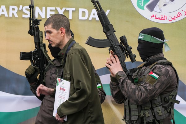 Israeli captive Or Levy, who has been held hostage by Hamas in Gaza since October 7, 2023, is escorted by Hamas fighters before being handed over to the Red Cross in Deir al-Balah, central Gaza Strip, Saturday Feb. 8, 2025. (AP Photo/Abdel Kareem Hana)