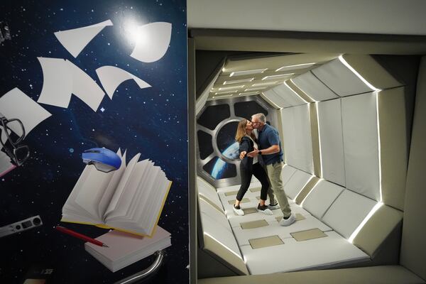 Argentine tourists Lilia, left, and Jose Auad kiss as they stand in a rotating capsule that is filmed with a moving cell phone to produce the illusion of zero gravity, at Paradox Museum Miami, Tuesday, Jan. 28, 2025, in Miami. (AP Photo/Rebecca Blackwell)