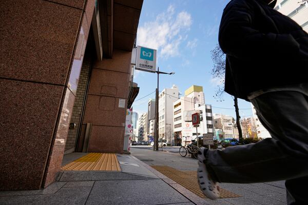 A subway sign, center top, is seen at the Kodenmacho station, that was affected by a deadly sarin nerve gas attack 30 years ago, in Tokyo, as a passenger gets out of its exit Thursday, March 20, 2025. (AP Photo/Hiro Komae)