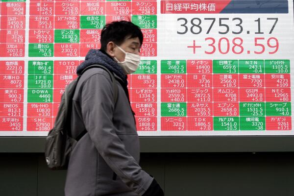 A person walks in front of an electronic stock board showing Japan's Nikkei index at a securities firm Thursday, Jan. 16, 2025, in Tokyo. (AP Photo/Eugene Hoshiko)