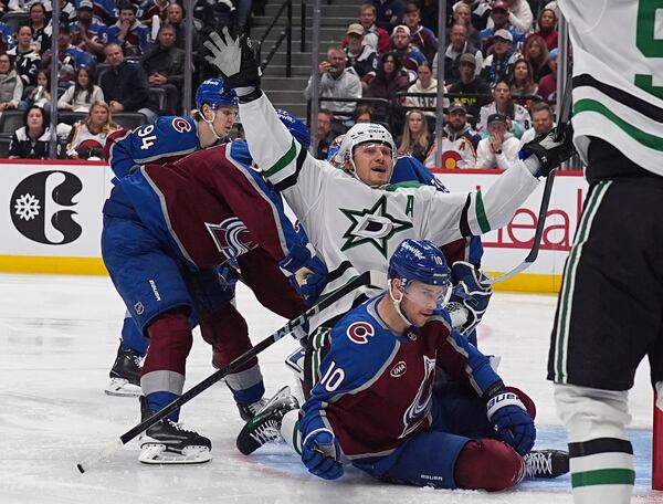 Dallas Stars center Roope Hintz, center top, celebrates after driving past Colorado Avalanche defenseman Ryan Lindgren, front left, and center Charlie Coyle (10) to score in the second period of Game 6 of an NHL hockey first-round playoff series Thursday, May 1, 2025, in Denver. (AP Photo/David Zalubowski)