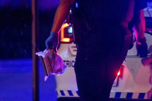 A Washington D.C. Metro police office carries an evidence bag to his car as law enforcement work the scene after two staff members of the Israeli Embassy in Washington were shot and killed outside the Capital Jewish Museum, Thursday, May 22, 2025, in Washington. (AP Photo/Rod Lamkey, Jr.)