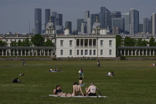People sunbathe on a sunny day at a park in London, Thursday, May 1, 2025. (AP Photo/Kin Cheung)