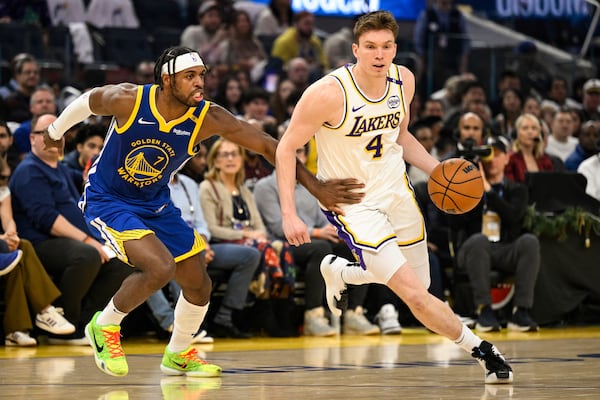 Los Angeles Lakers guard Dalton Knecht (4) dribbles against Golden State Warriors guard Buddy Hield (7) during the first half of an NBA basketball game, Wednesday, Dec. 25, 2024, in San Francisco. (AP Photo/Eakin Howard)