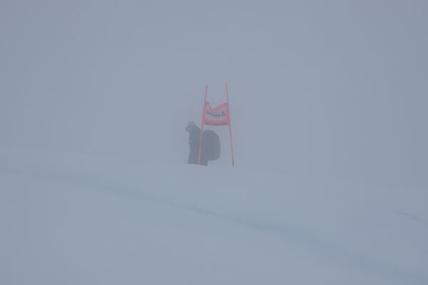 A gate is barely seen through the fog as an alpine ski, women's World Cup Super G race was canceled due to strong winds and poor visibility, in St. Moritz, Switzerland, Sunday, Dec. 22, 2024. (AP Photo/Marco Trovati)