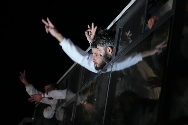 Freed Palestinian prisoners wave from a bus as they arrive in the Gaza Strip after being released from an Israeli prison following a ceasefire agreement between Hamas and Israel in Khan Younis, Gaza Strip, Thursday, Feb. 27, 2025. (AP Photo/Abdel Kareem Hana)