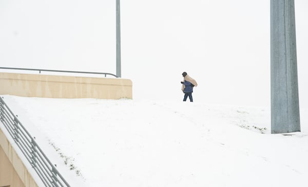 Frank Burnett walks on a snow covered overpass Thursday, Jan. 9, 2025, in Plano, Texas. (AP Photo/LM Otero)