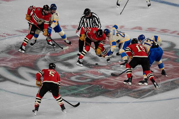 The Chicago Blackhawks and St. Louis Blues face off at center ice during the NHL Winter Classic outdoor hockey game at Wrigley Field, Tuesday, Dec. 31, 2024, in Chicago. (AP Photo/Erin Hooley)