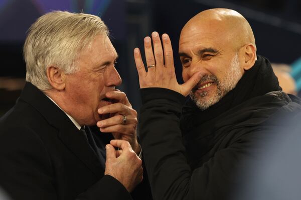 Real Madrid's head coach Carlo Ancelotti, left and Manchester City's head coach Pep Guardiola share a laugh before the Champions League playoff first leg soccer match between Manchester City and Real Madrid at the Etihad Stadium in Manchester, England, Tuesday, Feb. 11, 2025. (AP Photo/Darren Staples)