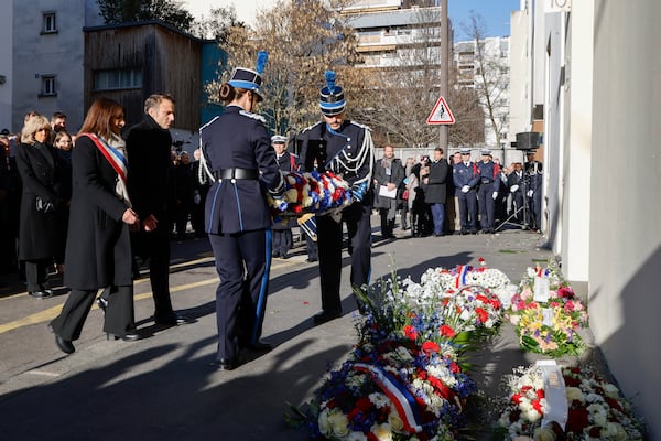 French President Emmanuel Macron, and Paris Mayor Anne Hidalgo, left, attend a commemoration marking 10 years since an Islamist attack on the Charlie Hebdo satirical newspaper and the Hypercacher jewish supermarket, outside the weekly's former offices in Paris Tuesday Jan. 7, 2025. (Ludovic Marin, Pool via AP)