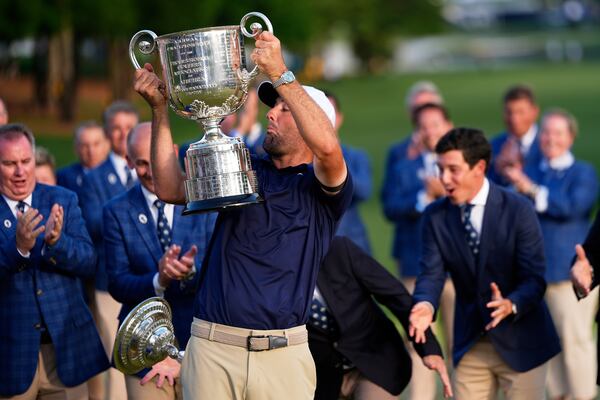 Scottie Scheffler drops the top as he holds the Wanamaker trophy after winning the PGA Championship golf tournament at the Quail Hollow Club, Sunday, May 18, 2025, in Charlotte, N.C. (AP Photo/David J. Phillip)
