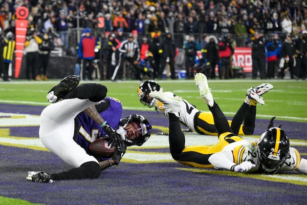 Baltimore Ravens wide receiver Rashod Bateman, left, catches a touchdown pass from quarterback Lamar Jackson, not visible, in front of Pittsburgh Steelers cornerback Donte Jackson (26) and cornerback Cameron Sutton during the first half of an NFL wild-card playoff football game, Saturday, Jan. 11, 2025, in Baltimore. (AP Photo/Nick Wass)