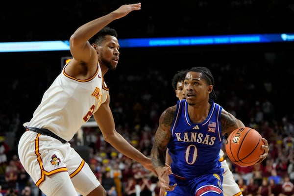 Kansas guard Shakeel Moore (0) drives past Iowa State forward Joshua Jefferson during the first half of an NCAA college basketball game, Wednesday, Jan. 15, 2025, in Ames, Iowa. (AP Photo/Charlie Neibergall)