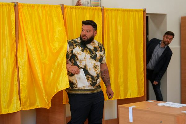 A man exits a voting booth before casting his vote in the first round of the presidential election redo in Bucharest, Romania, Sunday, May 4, 2025. (AP Photo/Vadim Ghirda)