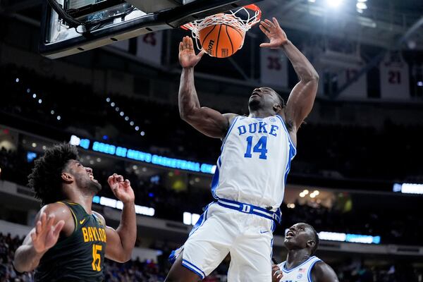 Duke guard Sion James dunks over Baylor forward Norchad Omier during the first half in the second round of the NCAA college basketball tournament, Sunday, March 23, 2025, in Raleigh, N.C. (AP Photo/Chris Carlson)