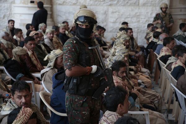 A Houthi soldier escorts released prisoners loyal to the Yemeni government after their release, in Sanaa, Yemen, Saturday, Jan. 25, 2025. (AP Photo/Osamah Abdulrahman)