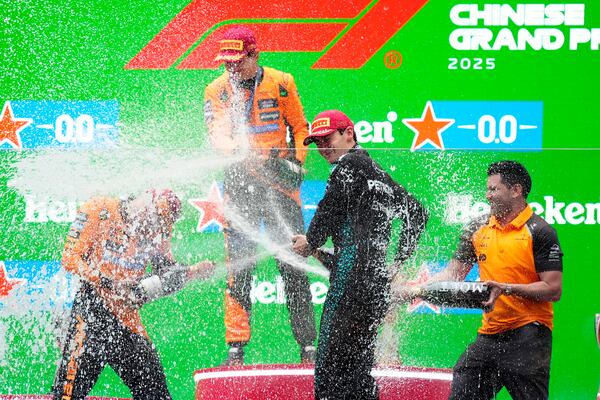 McLaren driver Oscar Piastri of Australia, McLaren driver Lando Norris of Britain and Mercedes driver George Russell of Britain celebrates on the podium after the Chinese Formula One Grand Prix race at the Shanghai International Circuit, Shanghai, Sunday, March 23, 2025. (AP Photo)