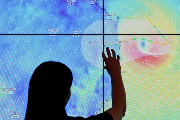 Staff look at a map showing Tropical Cyclone Alfred at the National Situation Room in Canberra, Australia, Thursday, March 6, 2025. (Lukas Coch/AAP Image via AP)