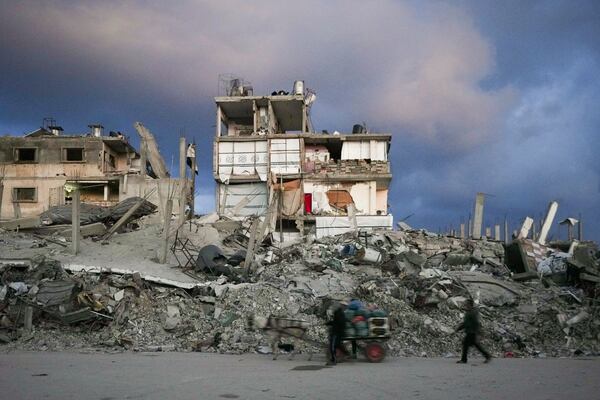 A man pushes a cart past a house that remains partly standing, but with sheets serving as makeshift walls, in an area largely destroyed by the Israeli army's air and ground offensive in Gaza City, Gaza Strip, Wednesday, Feb. 5, 2025. (AP Photo/Abdel Kareem Hana)