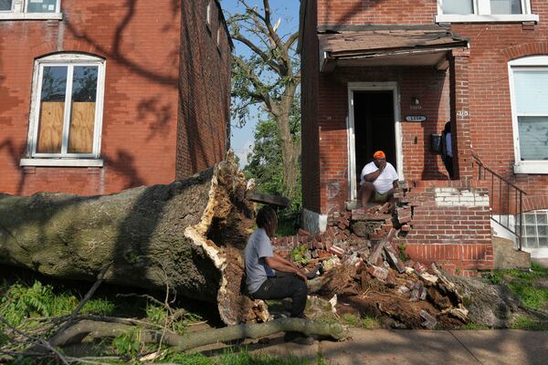 People survey damage after a severe storm moved through Friday, May 16, 2025, in St. Louis. (AP Photo/Jeff Roberson)