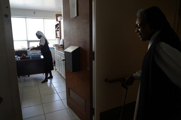 Sister Seyram Mary Adzokpa, left, works as a nurse as part of her ministry at the Sisters of the Holy Family in New Orleans, Tuesday, June 25, 2024. (AP Photo/Jessie Wardarski)