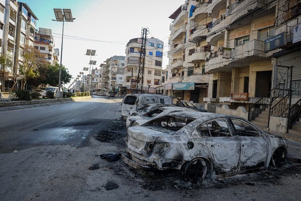 Burnt cars remain in the middle of a street following the recent wave of violence between Syrian security forces and gunmen loyal to former President Bashar Assad, as well as subsequent sectarian attacks, in the town of Jableh, Syria's coastal region, Monday, March 10, 2025. (AP Photo/Omar Albam)