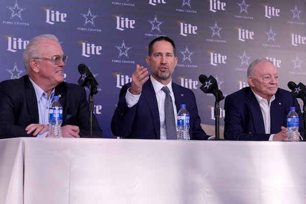 Brian Schottenheimer, center, makes comments as Dallas Cowboys Chief Operating Officer Stephen Jones, left, and team owner Jerry Jones, right, listen during a news conference where Schottenheimer was introduced as the new head coach at the team's headquarters in Frisco, Texas, Monday, Jan. 27, 2025. (AP Photo/Tony Gutierrez)