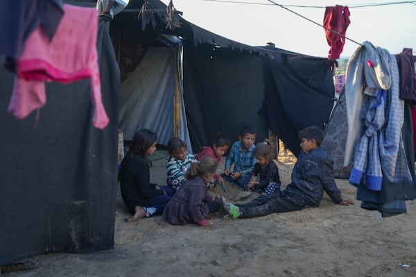 Grandchildren of Reda Abu Zarada, displaced from Jabaliya in northern Gaza, play next to their tent at a camp in Khan Younis, Gaza Strip, Thursday, Dec. 19, 2024. (AP Photo/Abdel Kareem Hana)