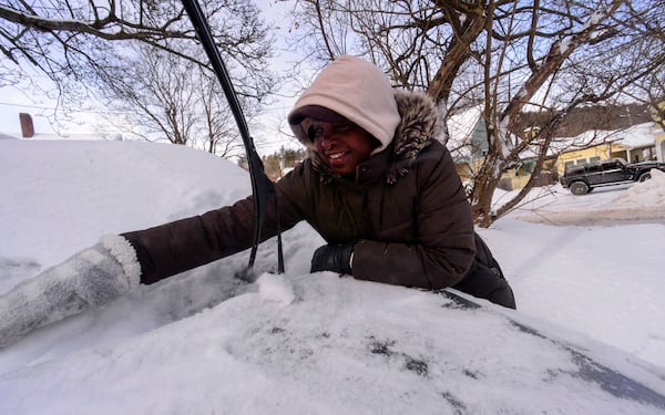 Bryana Worthy uses her hands to help break up some of the ice chunks on her vehicle on Monday, Feb. 17, 2025, in Brattleboro, Vt., after a winter storm on Sunday. (Kristopher Radder/The Brattleboro Reformer via AP)