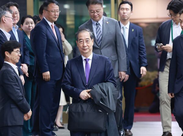 South Korean acting President Han Duck-soo, center, leaves after a press conference announcing his resignation at the Government Complex in Seoul, South Korea, Thursday, May 1, 2025. (Hong Hae-in/Yonhap via AP)