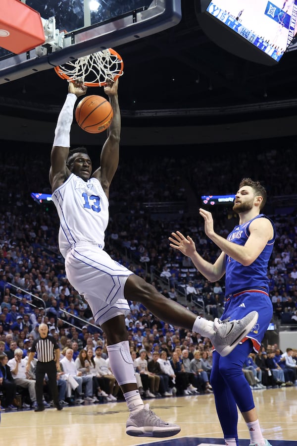 BYU center Keba Keita (13) dunks against Kansas center Hunter Dickinson during the first half of an NCAA college basketball game Tuesday, Feb. 18, 2025, in Provo, Utah. (AP Photo/Rob Gray)