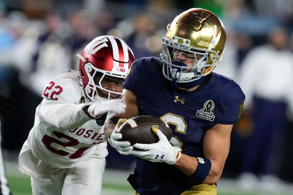 Notre Dame wide receiver Jordan Faison (6) catches a pass as Indiana defensive back Jamari Sharpe (22) defends during the second half in the first round of the NCAA College Football Playoff, Friday, Dec. 20, 2024, in South Bend, Ind. (AP Photo/Darron Cummings)