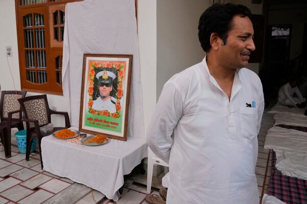 Sunil Swami stands next to a framed portrait of his son-in-law and Indian naval officer Vinay Narwal, who was killed by militants at Pahalgam in Indian controlled Kashmir, at Narwal's home in Karnal, India, Tuesday, April 29, 2025.(AP Photo/Manish Swarup)