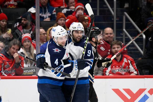 Winnipeg Jets left wing Alex Iafallo (9) celebrates his goal with defenseman Neal Pionk (4) during the second period of an NHL hockey game against the Washington Capitals, Saturday, Feb. 1, 2025, in Washington. (AP Photo/Nick Wass)