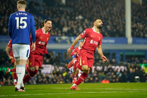 Liverpool's Mohamed Salah, right, celebrates after scoring his side's second goal during the English Premier League soccer match between Everton and Liverpool, Liverpool, England, Wednesday, Feb.12, 2025. (AP Photo/Dave Thompson)