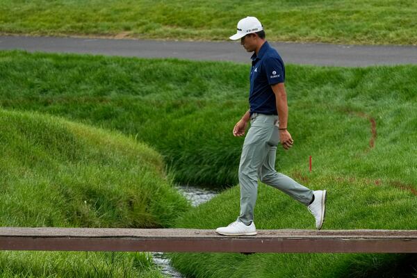 Collin Morikawa walks across a bridge on the second hole during the first round of the Memorial golf tournament, Thursday, May 29, 2025, in Dublin, Ohio. (AP Photo/Sue Ogrocki)